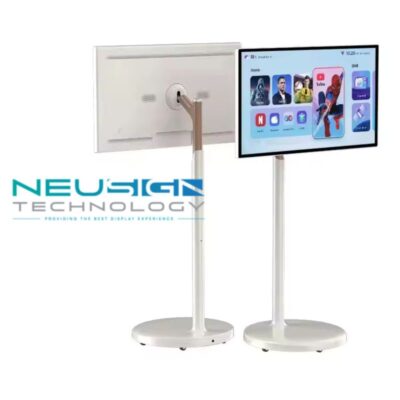 A slim, white smart screen on a sleek rolling floor stand positioned next to a cozy armchair.